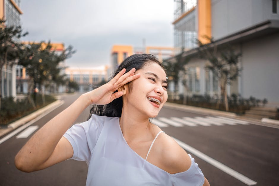 Happy woman with braces smiling on an urban street in daylight.