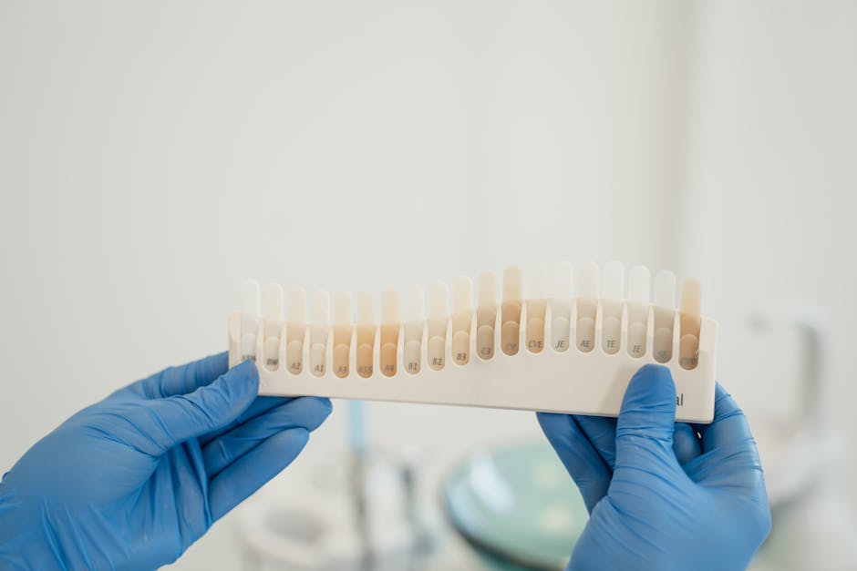 Dentist using a tooth shade guide to match patient's tooth color accurately during treatment.