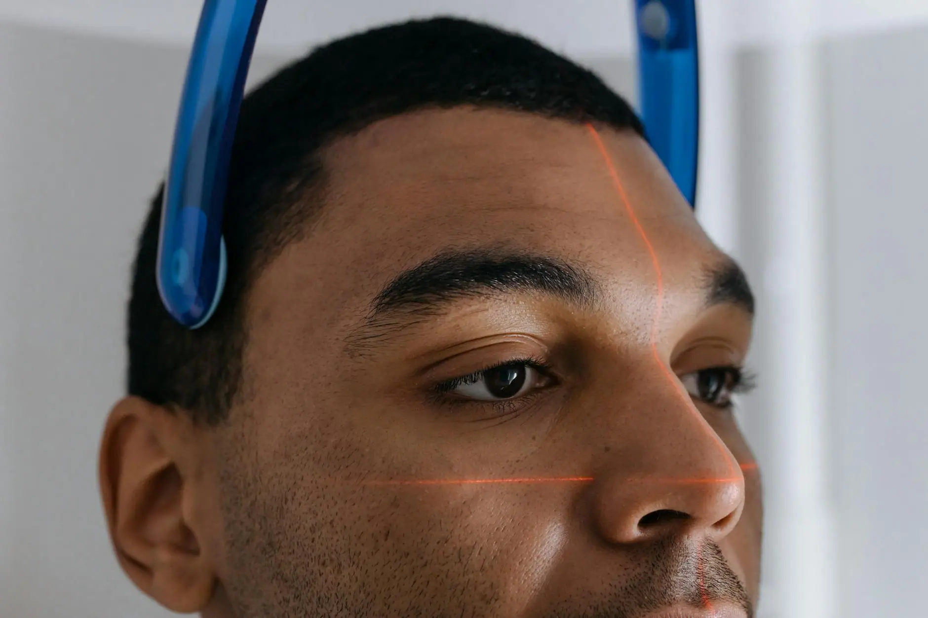 Man undergoing a dental CT scan with laser alignment in a clinic setting.
