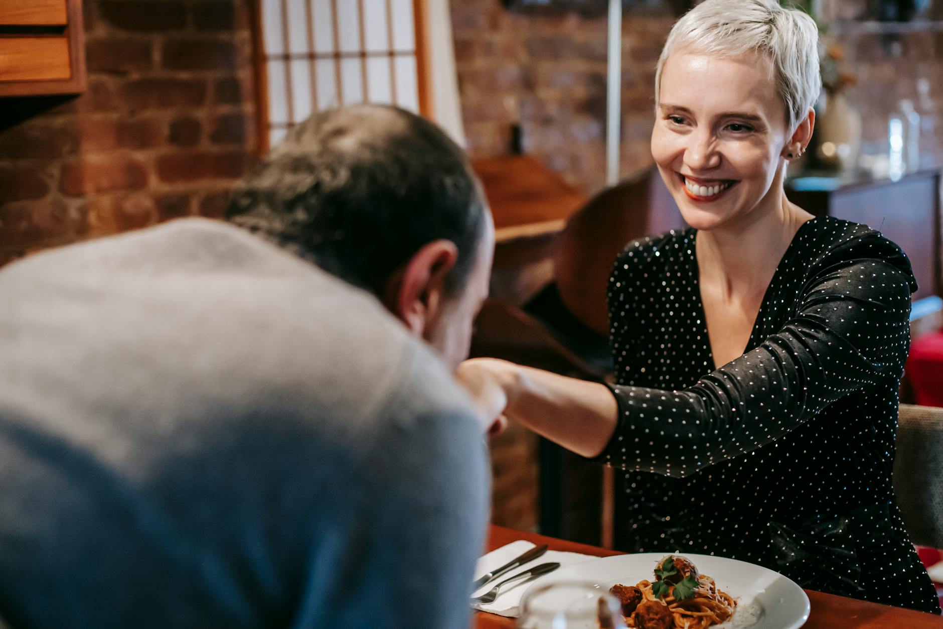 Couple enjoying dinner confidently with beautiful veneer smiles